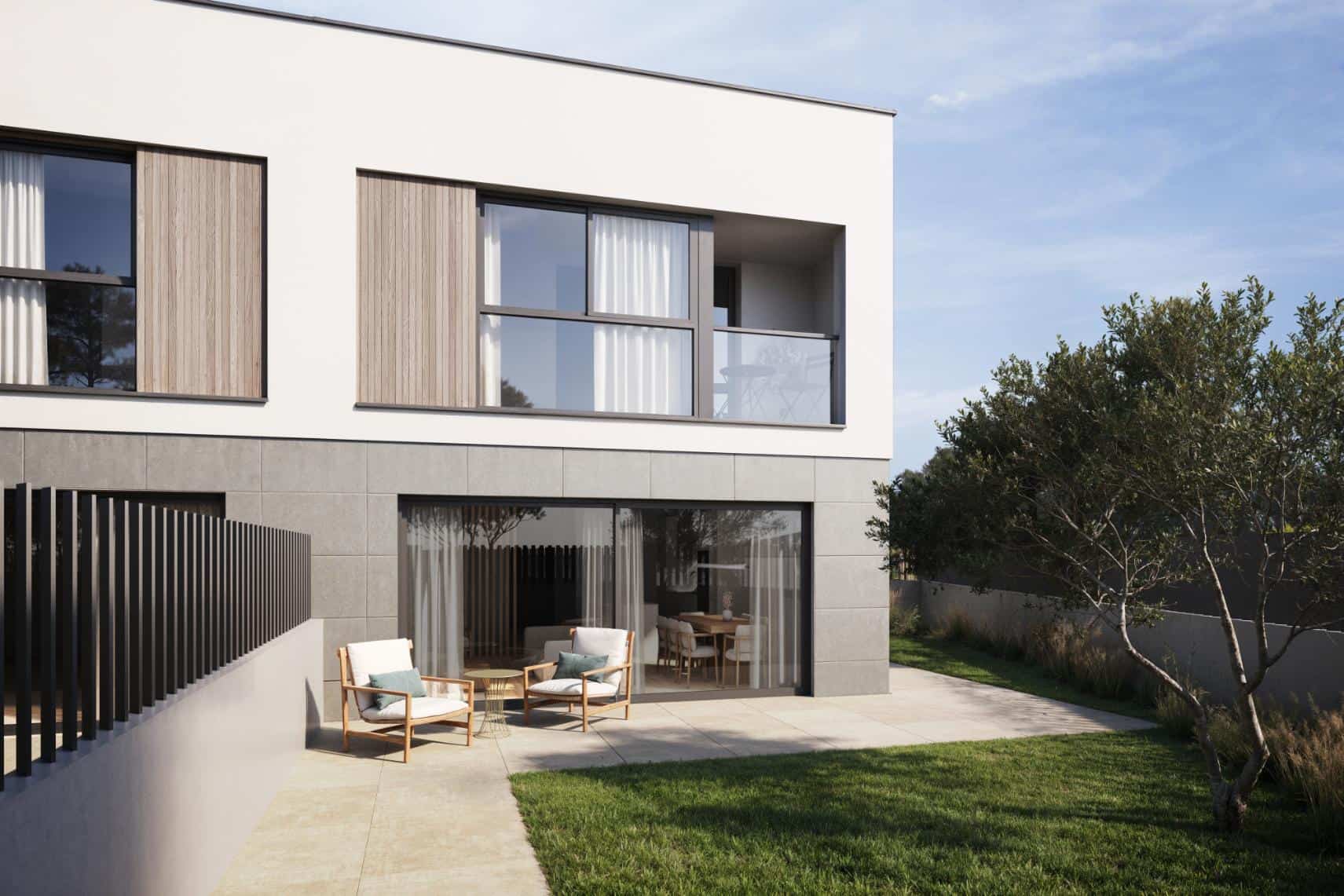 Jardí privat amb mobiliari exterior en una casa adossada d’obra nova a Palau-solità i Plegamans, amb grans finestrals i acabats moderns.