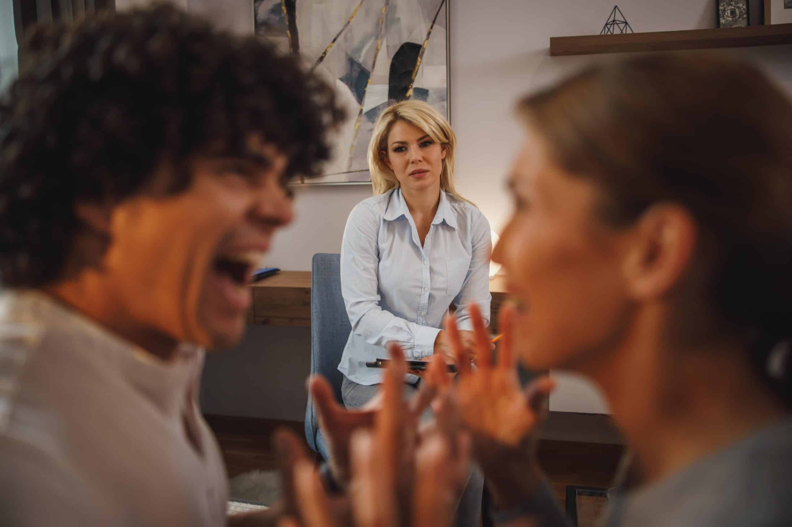Discussió entre germans davant una mediadora, simbolitzant els conflictes familiars derivats d’una herència no planificada.