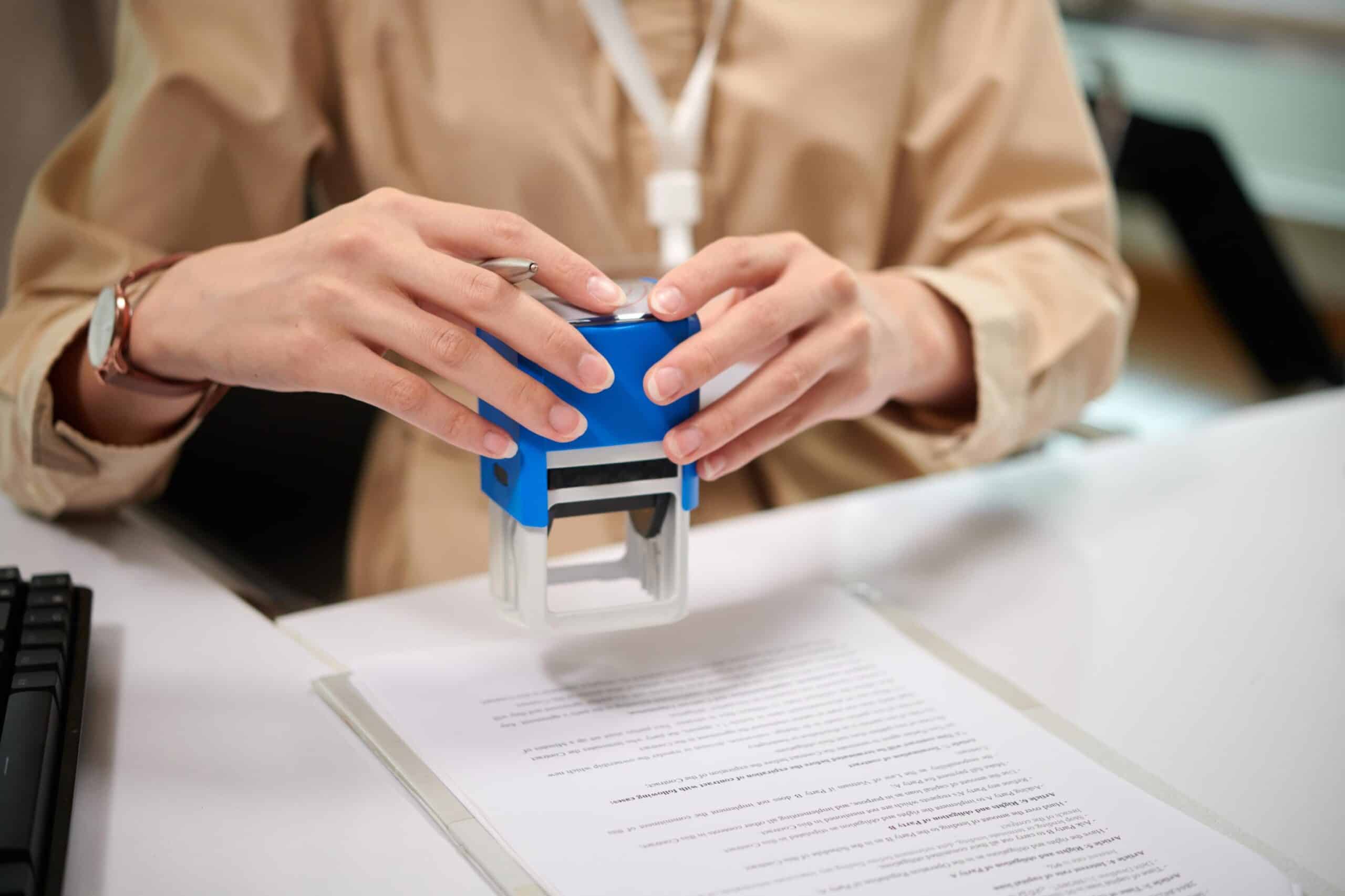 Persona segellant un document legal, representant la preparació de poders notarials en fase preventiva per designar un representant legal de confiança.